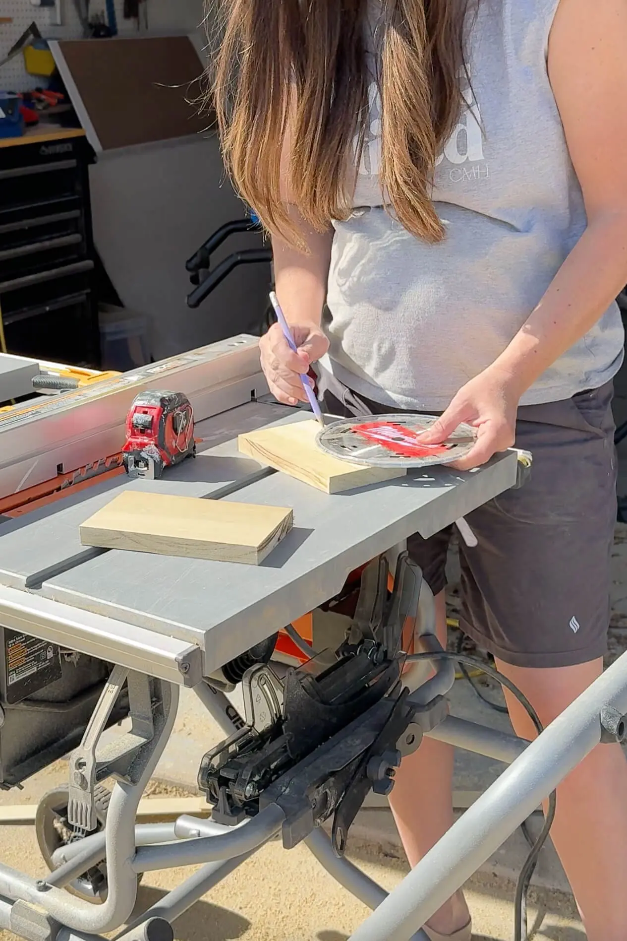 DIYer tracing a woodcut template for a nursery bookshelf using a blade and pencil on a table saw.